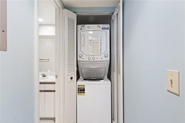 washroom featuring stacked washer and dryer and sink