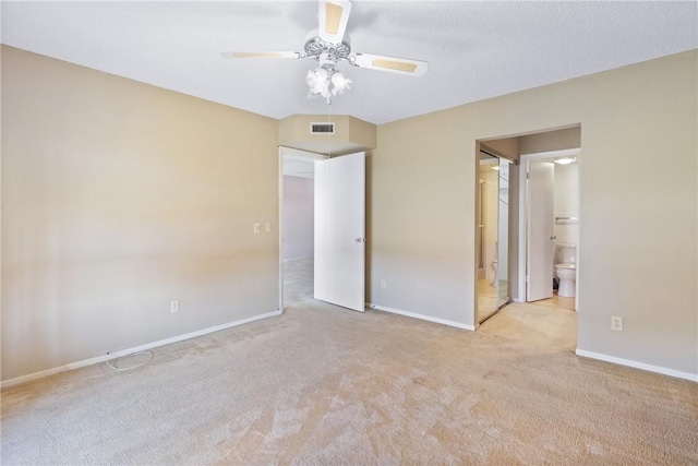 unfurnished bedroom with light carpet, ensuite bathroom, and ceiling fan