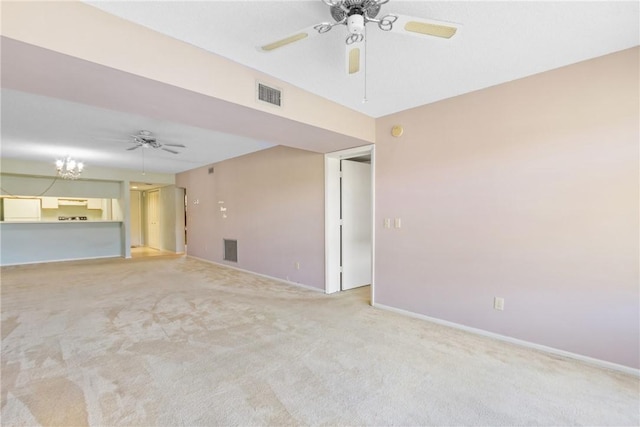 unfurnished room featuring light colored carpet and an inviting chandelier