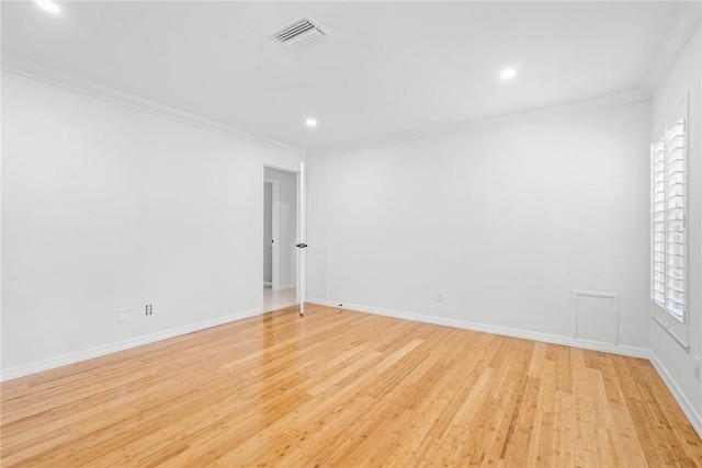 spare room with light hardwood / wood-style flooring and crown molding