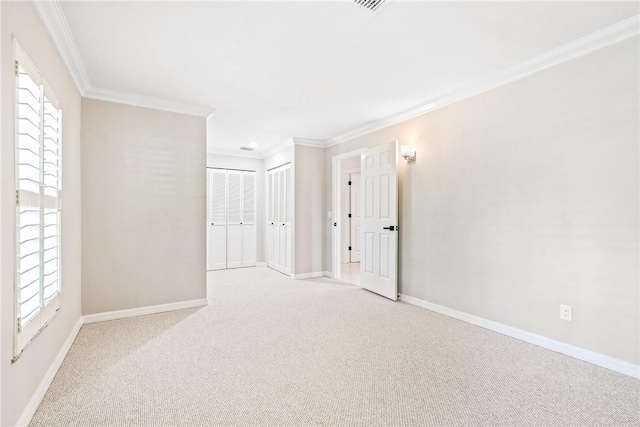 spare room featuring light carpet and crown molding