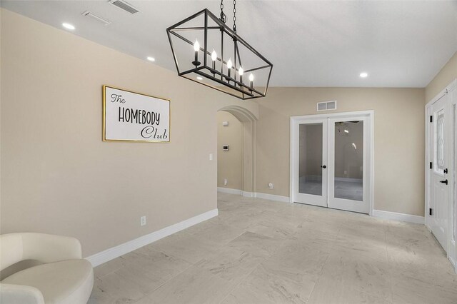 interior space featuring arched walkways, french doors, visible vents, and baseboards