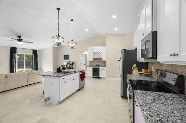 kitchen with stainless steel appliances, wine cooler, open floor plan, and white cabinetry