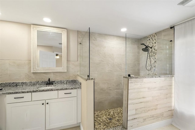 bathroom featuring recessed lighting, visible vents, a walk in shower, and vanity