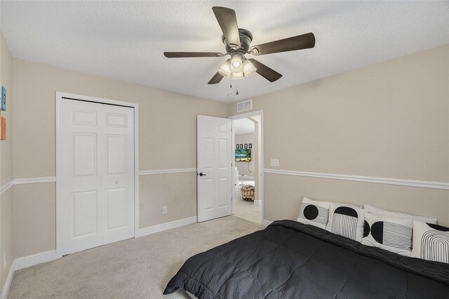 carpeted bedroom with baseboards, a closet, visible vents, and a ceiling fan