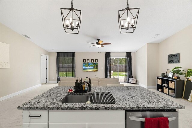 kitchen with light stone countertops, visible vents, open floor plan, and a sink