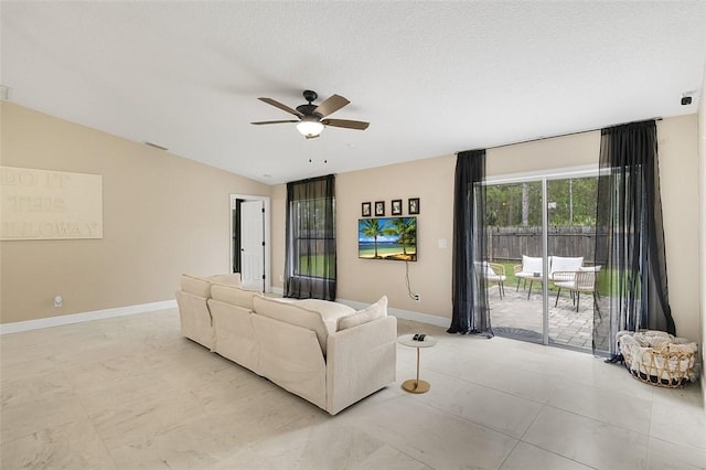 living area featuring lofted ceiling, ceiling fan, a textured ceiling, visible vents, and baseboards