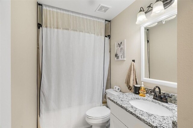 full bathroom featuring toilet, shower / bath combo with shower curtain, vanity, and visible vents