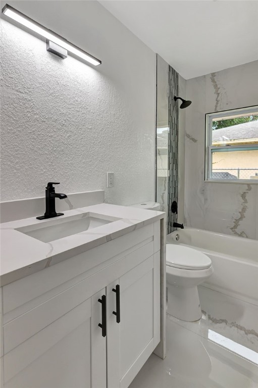 full bathroom featuring toilet, vanity, and tiled shower / bath