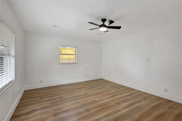 unfurnished room featuring a textured ceiling, hardwood / wood-style flooring, and ceiling fan