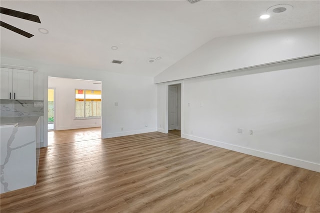 unfurnished living room with ceiling fan, light hardwood / wood-style flooring, and vaulted ceiling