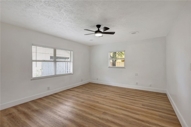 empty room featuring ceiling fan, a textured ceiling, and hardwood / wood-style flooring