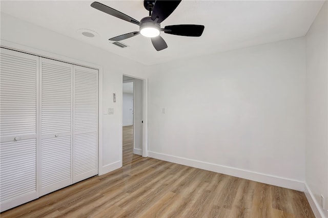 unfurnished bedroom with ceiling fan, a closet, and light hardwood / wood-style floors