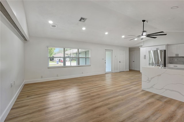 unfurnished living room featuring ceiling fan, light hardwood / wood-style flooring, and vaulted ceiling