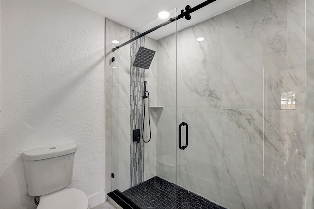 bathroom with toilet and a shower with shower door