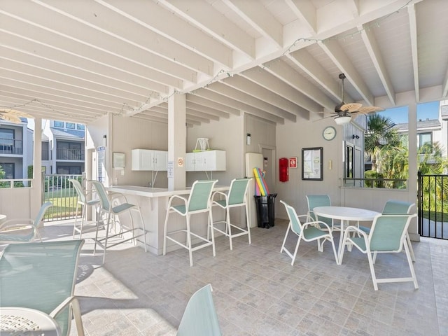 view of patio featuring ceiling fan and a bar