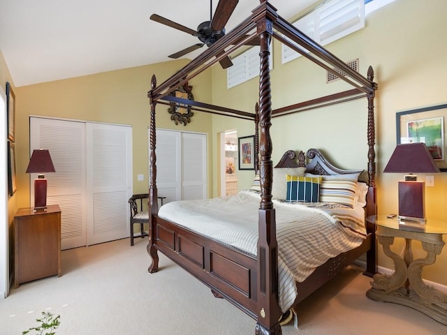 bedroom featuring vaulted ceiling, carpet floors, ceiling fan, and multiple closets