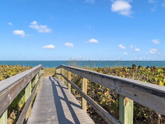 view of property's community with a water view and a view of the beach