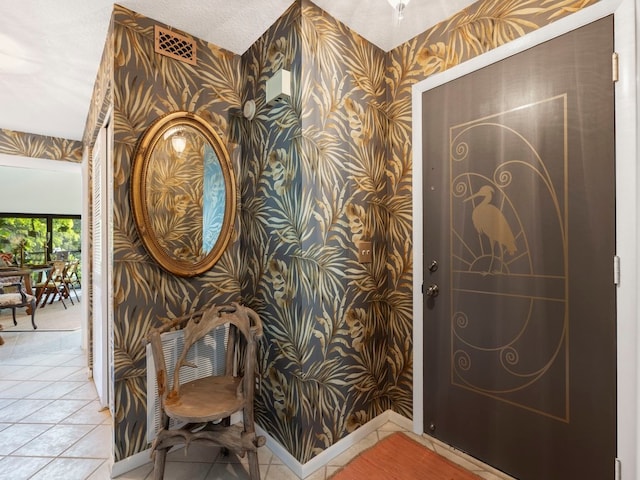 interior space featuring light tile patterned flooring and a textured ceiling