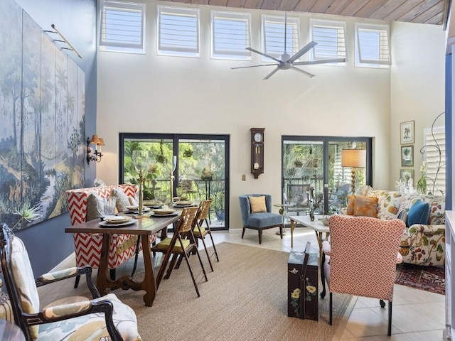 interior space with ceiling fan, a high ceiling, and light tile patterned floors