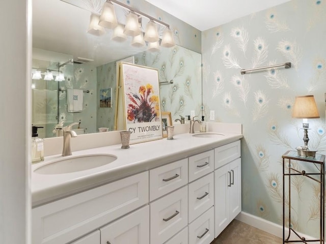 full bath featuring baseboards, double vanity, a sink, and wallpapered walls