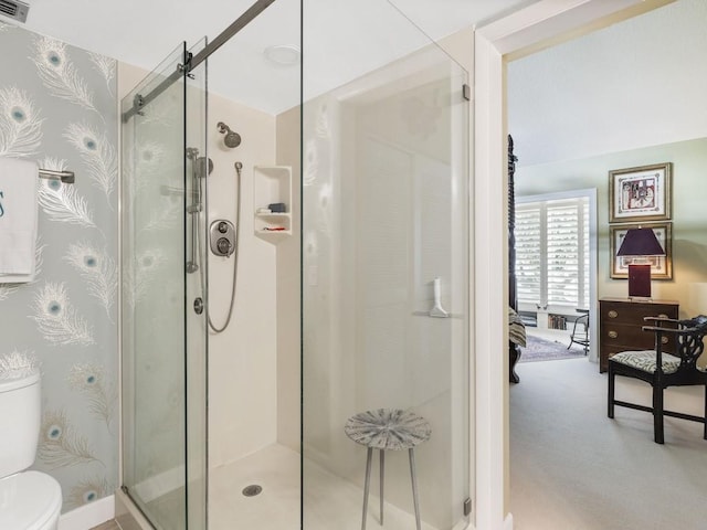 bathroom with a shower with door and toilet