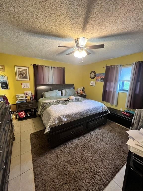 bedroom featuring ceiling fan, light tile patterned flooring, and a textured ceiling