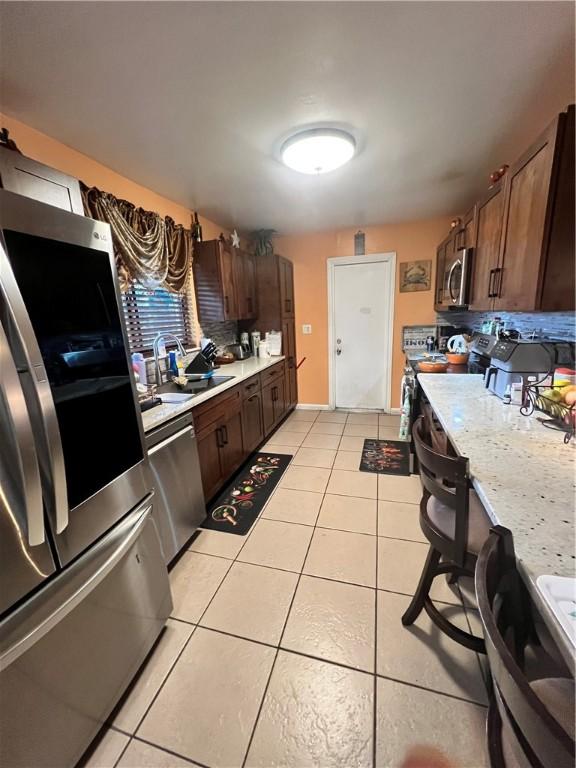 kitchen featuring light tile patterned floors, sink, and appliances with stainless steel finishes