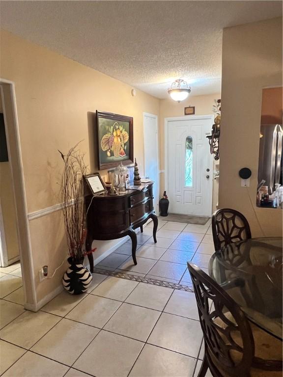 entrance foyer featuring light tile patterned floors and a textured ceiling