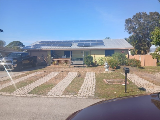 single story home with a porch and solar panels