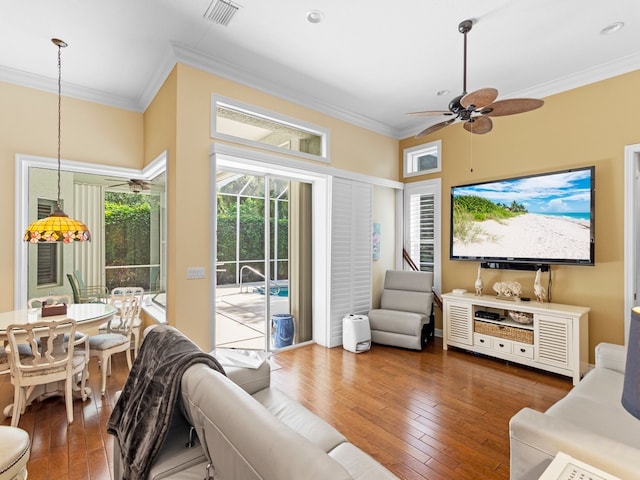 living room with dark hardwood / wood-style flooring, ceiling fan, and crown molding