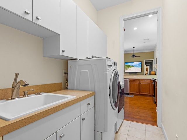 clothes washing area with cabinets, sink, ornamental molding, ceiling fan, and light hardwood / wood-style flooring