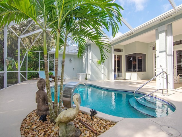 view of pool with a patio area, a lanai, and pool water feature