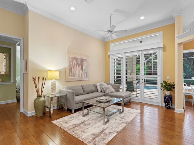 living room with hardwood / wood-style flooring, ceiling fan, and ornamental molding