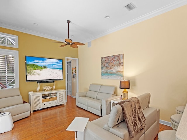 living room featuring ornamental molding, light wood-type flooring, and ceiling fan