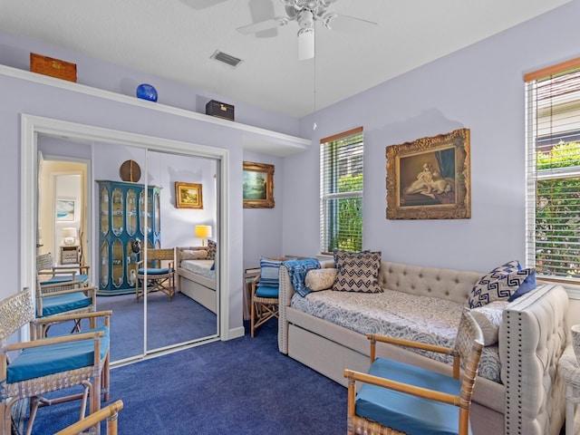 carpeted living room featuring a textured ceiling, ceiling fan, and plenty of natural light