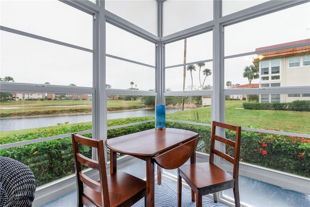 sunroom featuring a water view