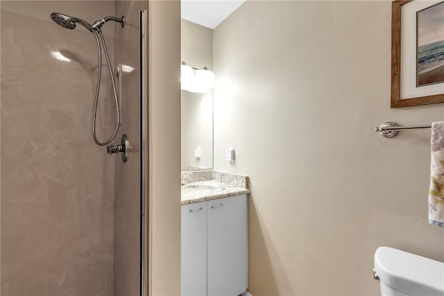 bathroom featuring walk in shower, vanity, and toilet