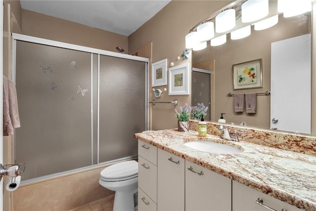 full bathroom with shower / bath combination with glass door, vanity, toilet, and tile patterned flooring