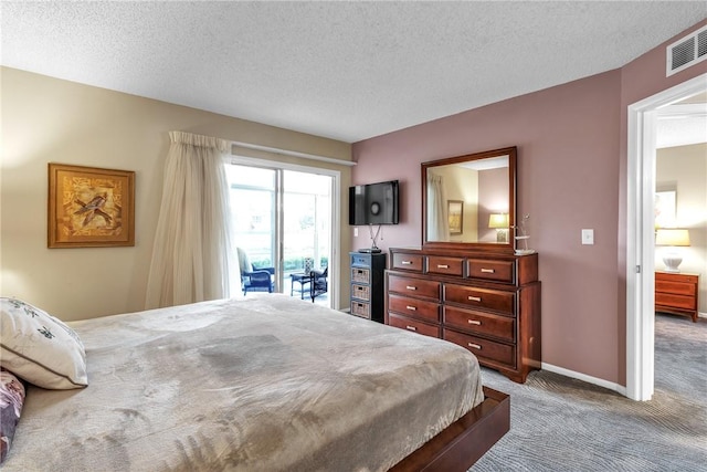 carpeted bedroom with access to exterior and a textured ceiling