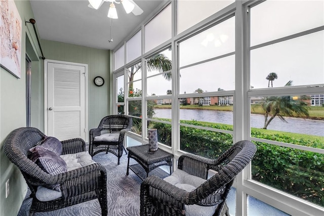 sunroom with a water view and ceiling fan