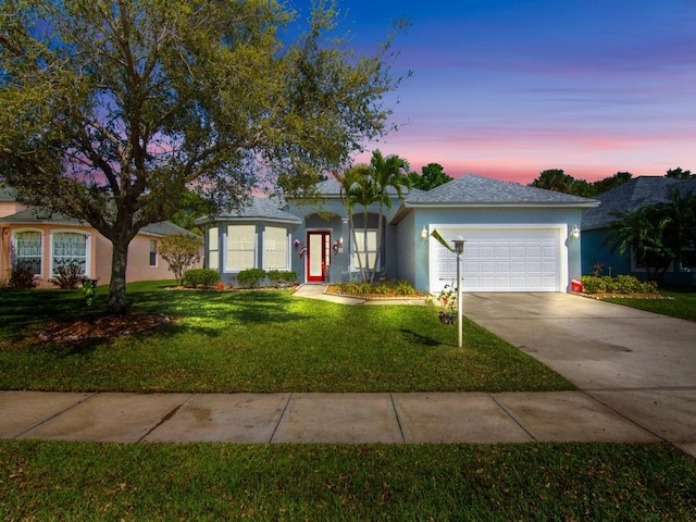 single story home featuring a garage, concrete driveway, a front yard, and stucco siding