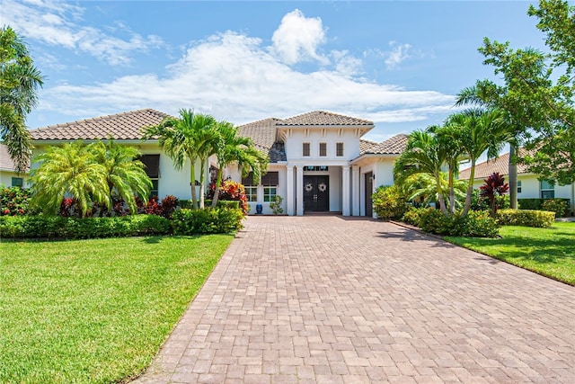 mediterranean / spanish home with a garage and a front yard