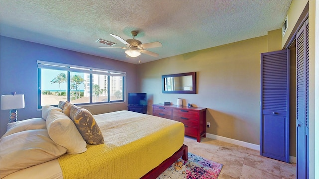 bedroom featuring ceiling fan, a textured ceiling, and a closet