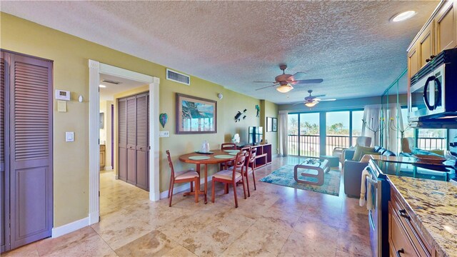 dining room featuring a textured ceiling and ceiling fan