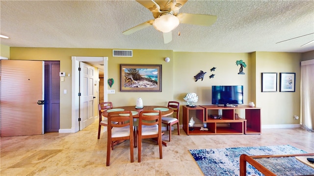 dining space featuring a textured ceiling and ceiling fan