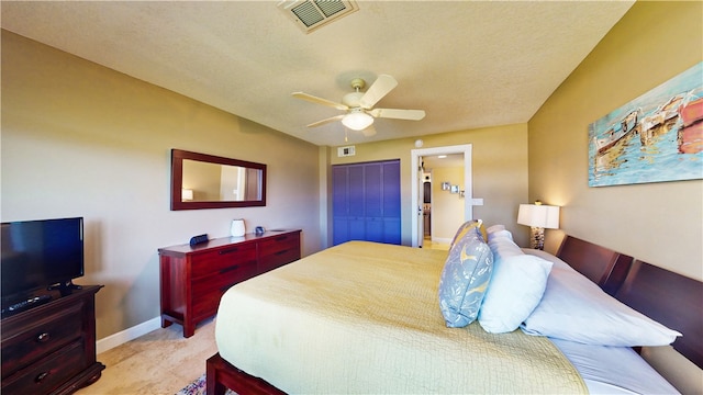 bedroom with ceiling fan, ensuite bath, a closet, and a textured ceiling