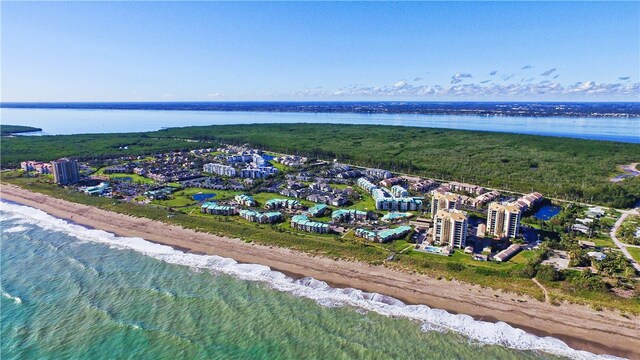 birds eye view of property featuring a water view and a beach view