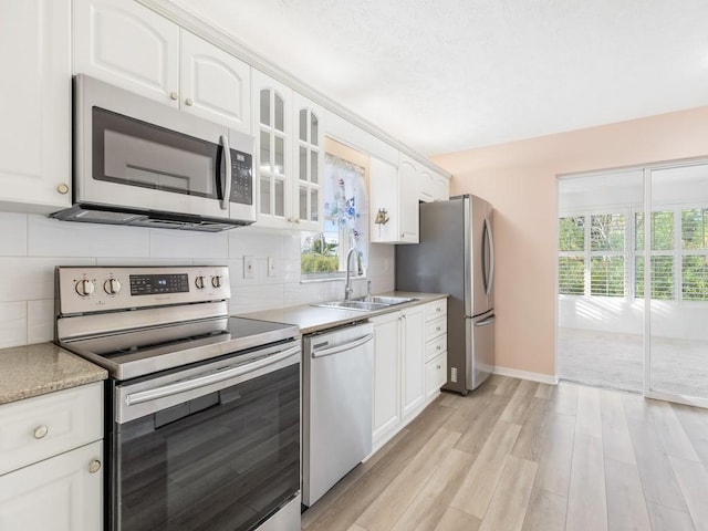 kitchen featuring white cabinetry, sink, tasteful backsplash, and stainless steel appliances