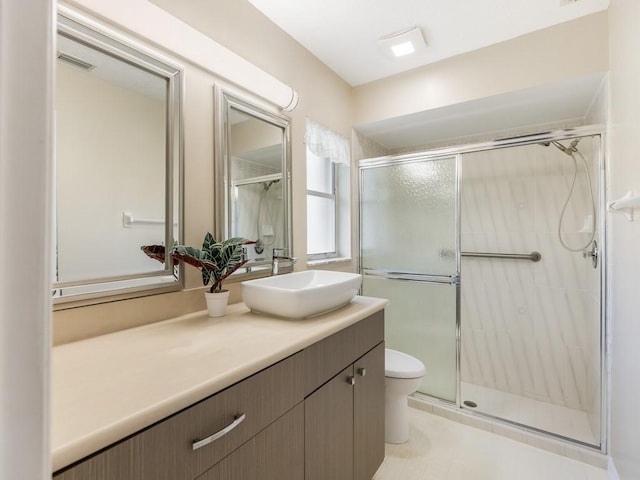 bathroom featuring vanity, toilet, and a shower with shower door